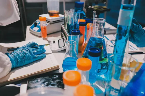 Bilimadamı laboratuarda tıbbi örnekleri mikro plakaya yerleştiriyor.