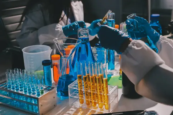 Bilimadamı laboratuarda tıbbi örnekleri mikro plakaya yerleştiriyor.