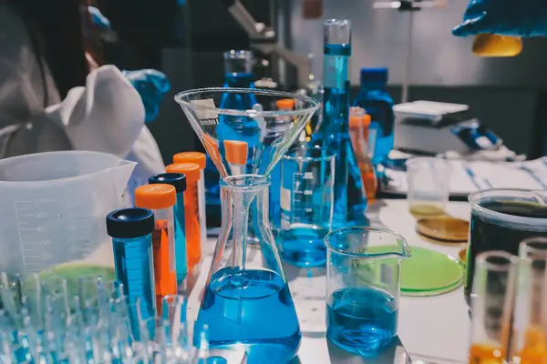 Bilimadamı laboratuarda tıbbi örnekleri mikro plakaya yerleştiriyor.