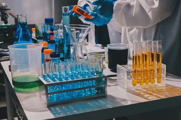 Bilimadamı laboratuarda tıbbi örnekleri mikro plakaya yerleştiriyor.