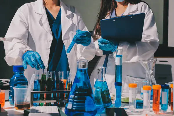 Bilimadamı laboratuarda tıbbi örnekleri mikro plakaya yerleştiriyor.