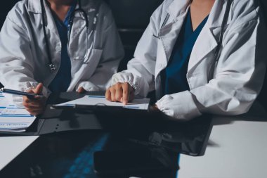 Erkek ve kadın doktorlar bir hastane odasında toplantı yapıyorlar..