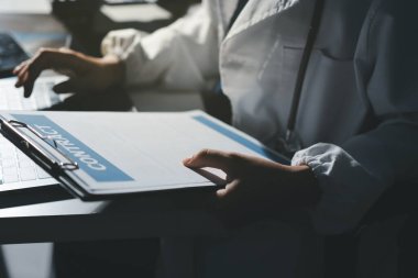 Erkek ve kadın doktorlar bir hastane odasında toplantı yapıyorlar..