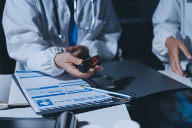 Erkek ve kadın doktorlar bir hastane odasında toplantı yapıyorlar..