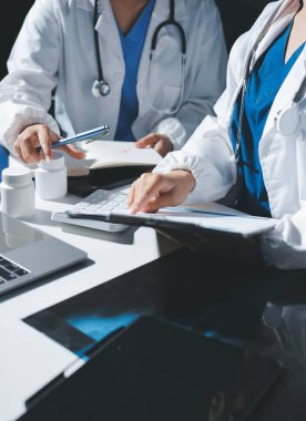 Erkek ve kadın doktorlar bir hastane odasında toplantı yapıyorlar..