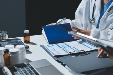 Erkek ve kadın doktorlar bir hastane odasında toplantı yapıyorlar..