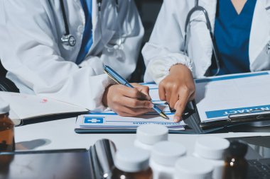 Erkek ve kadın doktorlar bir hastane odasında toplantı yapıyorlar..