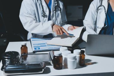 Erkek ve kadın doktorlar bir hastane odasında toplantı yapıyorlar..