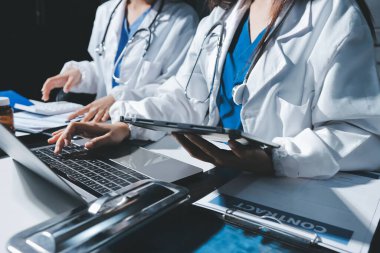 Erkek ve kadın doktorlar bir hastane odasında toplantı yapıyorlar..