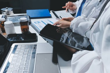 Erkek ve kadın doktorlar bir hastane odasında toplantı yapıyorlar..