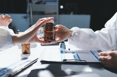 Erkek ve kadın doktorlar bir hastane odasında toplantı yapıyorlar..