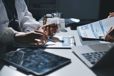 Erkek ve kadın doktorlar bir hastane odasında toplantı yapıyorlar..