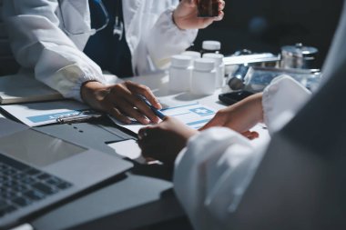 Erkek ve kadın doktorlar bir hastane odasında toplantı yapıyorlar..