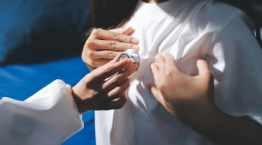 Konuşurken kalp atışı ve semptomlarını incelemek için steteskop kullanan erkek doktorun el görüntüsü.