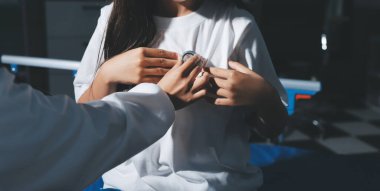 Konuşurken kalp atışı ve semptomlarını incelemek için steteskop kullanan erkek doktorun el görüntüsü.