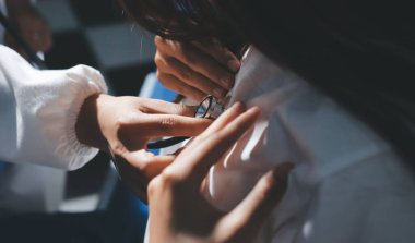 Konuşurken kalp atışı ve semptomlarını incelemek için steteskop kullanan erkek doktorun el görüntüsü.