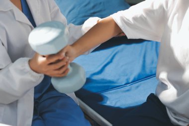 Tanımlanamayan fiziksel terapi sırasında mavi el ağırlığı kullanır