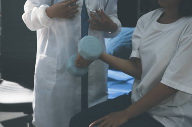 Tanımlanamayan fiziksel terapi sırasında mavi el ağırlığı kullanır