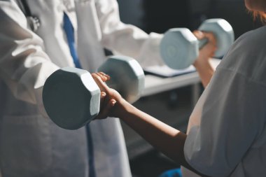 Tanımlanamayan fiziksel terapi sırasında mavi el ağırlığı kullanır