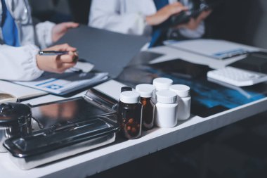 Erkek ve kadın doktorlar bir hastane odasında toplantı yapıyorlar..