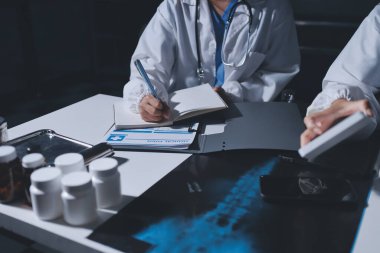 Erkek ve kadın doktorlar bir hastane odasında toplantı yapıyorlar..