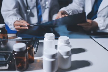 Erkek ve kadın doktorlar bir hastane odasında toplantı yapıyorlar..