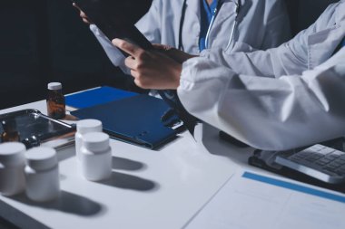 Erkek ve kadın doktorlar bir hastane odasında toplantı yapıyorlar..