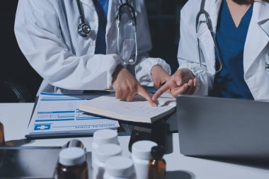 Erkek ve kadın doktorlar bir hastane odasında toplantı yapıyorlar..