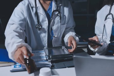 Erkek ve kadın doktorlar bir hastane odasında toplantı yapıyorlar..