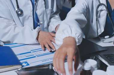 Erkek ve kadın doktorlar bir hastane odasında toplantı yapıyorlar..