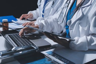 Erkek ve kadın doktorlar bir hastane odasında toplantı yapıyorlar..