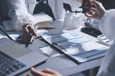 Erkek ve kadın doktorlar bir hastane odasında toplantı yapıyorlar..