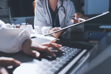 Erkek ve kadın doktorlar bir hastane odasında toplantı yapıyorlar..