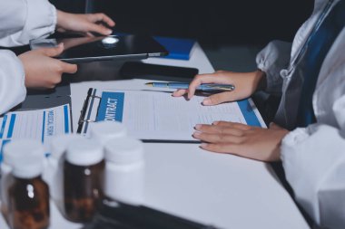 Erkek ve kadın doktorlar bir hastane odasında toplantı yapıyorlar..