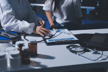 Konuşurken kalp atışı ve semptomlarını incelemek için steteskop kullanan erkek doktorun el görüntüsü.