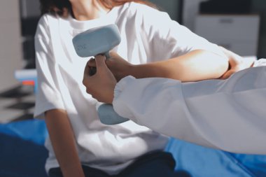 Tanımlanamayan fiziksel terapi sırasında mavi el ağırlığı kullanır