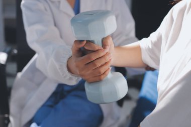 Tanımlanamayan fiziksel terapi sırasında mavi el ağırlığı kullanır