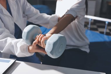 Tanımlanamayan fiziksel terapi sırasında mavi el ağırlığı kullanır