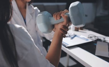 Tanımlanamayan fiziksel terapi sırasında mavi el ağırlığı kullanır