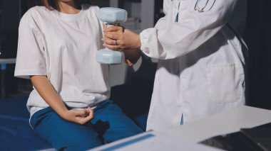 Tanımlanamayan fiziksel terapi sırasında mavi el ağırlığı kullanır