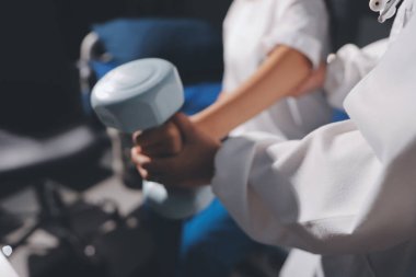 Tanımlanamayan fiziksel terapi sırasında mavi el ağırlığı kullanır