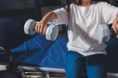 Tanımlanamayan fiziksel terapi sırasında mavi el ağırlığı kullanır