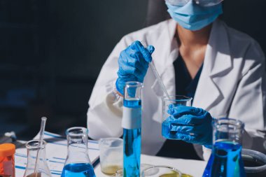 Bilimadamı laboratuarda tıbbi örnekleri mikro plakaya yerleştiriyor.