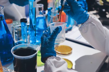 Bilimadamı laboratuarda tıbbi örnekleri mikro plakaya yerleştiriyor.