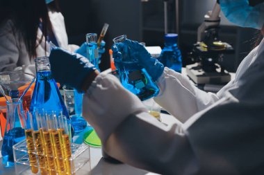 Bilimadamı laboratuarda tıbbi örnekleri mikro plakaya yerleştiriyor.