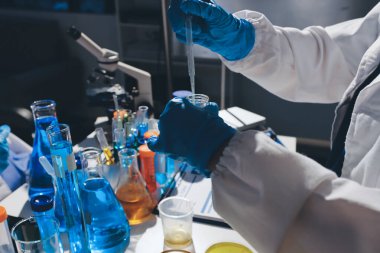 Bilimadamı laboratuarda tıbbi örnekleri mikro plakaya yerleştiriyor.