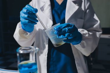 Bilimadamı laboratuarda tıbbi örnekleri mikro plakaya yerleştiriyor.