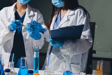 Bilimadamı laboratuarda tıbbi örnekleri mikro plakaya yerleştiriyor.