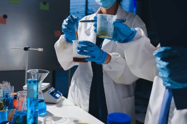 Bilimadamı laboratuarda tıbbi örnekleri mikro plakaya yerleştiriyor.