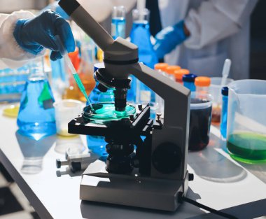 Bilimadamı laboratuarda tıbbi örnekleri mikro plakaya yerleştiriyor.